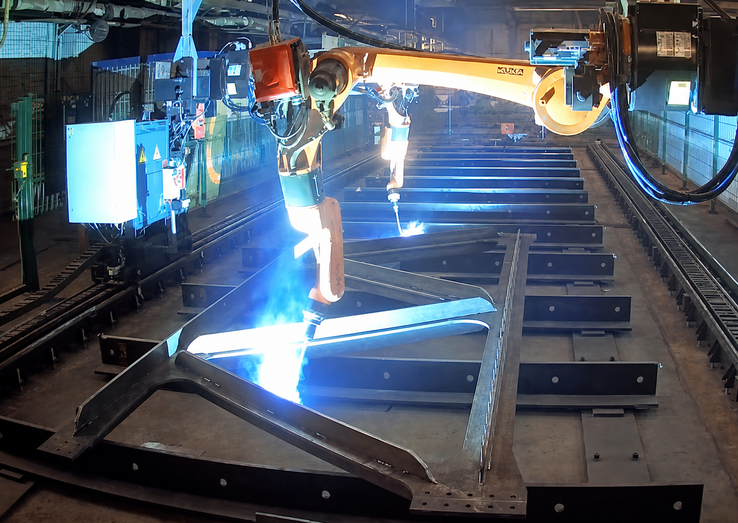 Twin robotic cells welding a steel frame